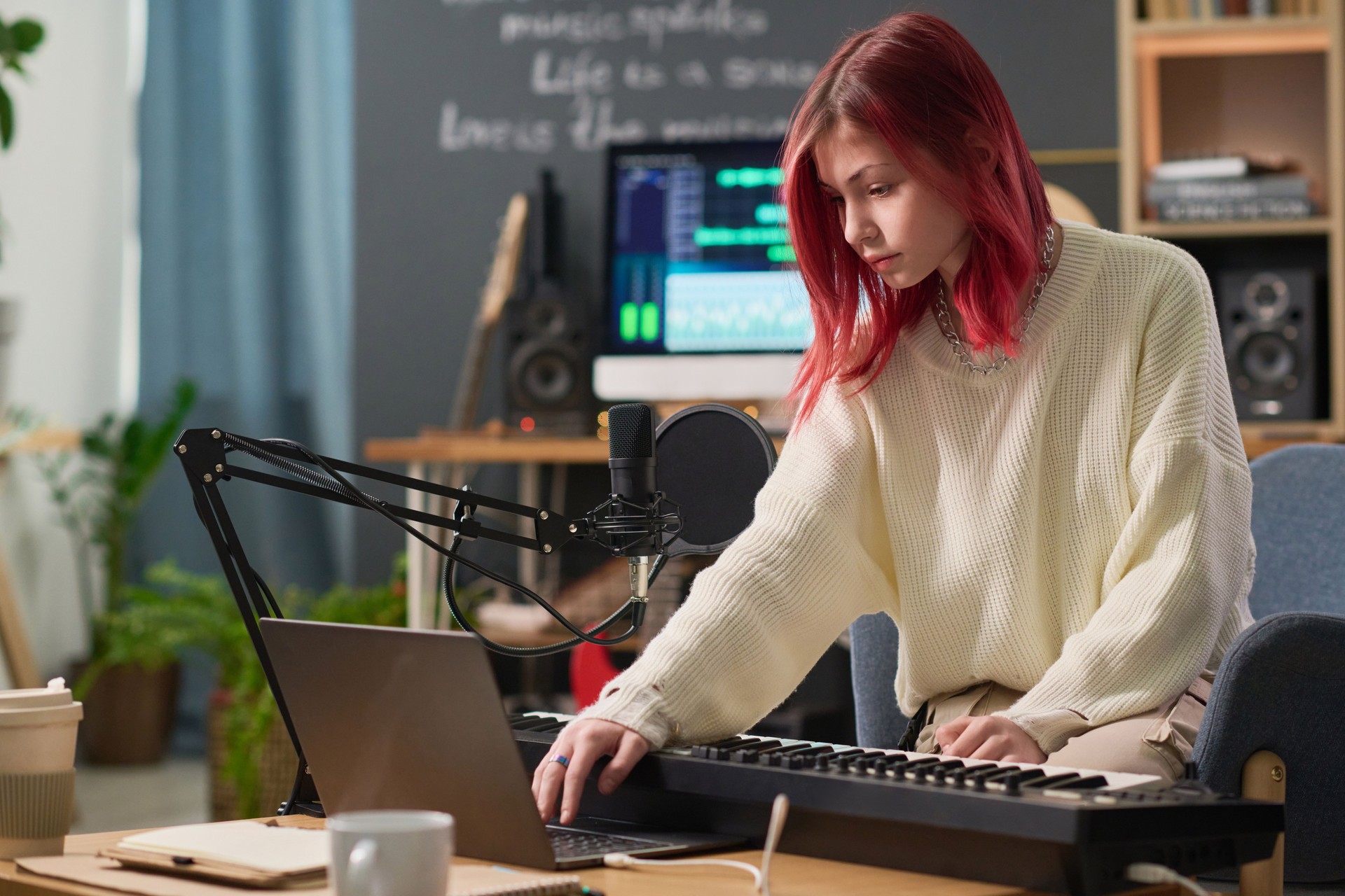 Teenage musician using laptop in studio